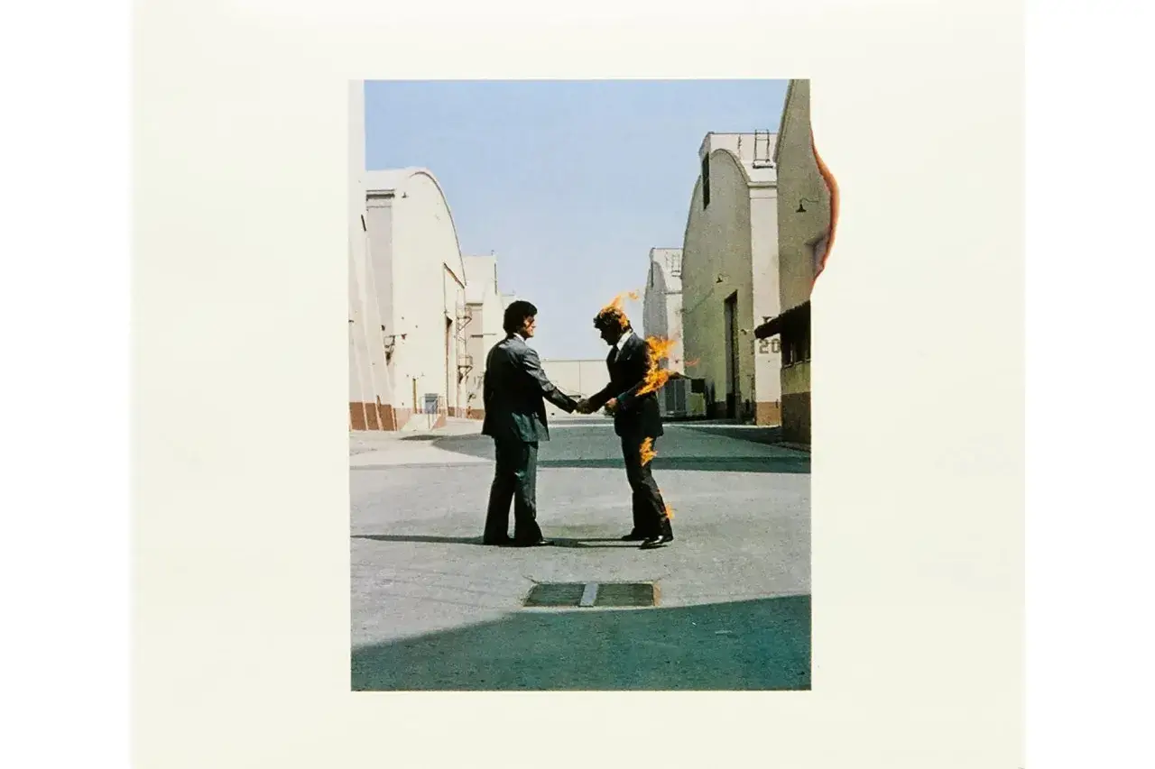 Pochette de l'album Pink Floyd "Wish You Were Here" : deux hommes se serrent la main, l'un d'eux est en feu.