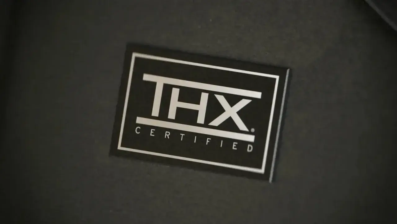 Autocollant argenté THX CERTIFIED sur fond noir. Gage de qualité sonore pour une expérience immersive.