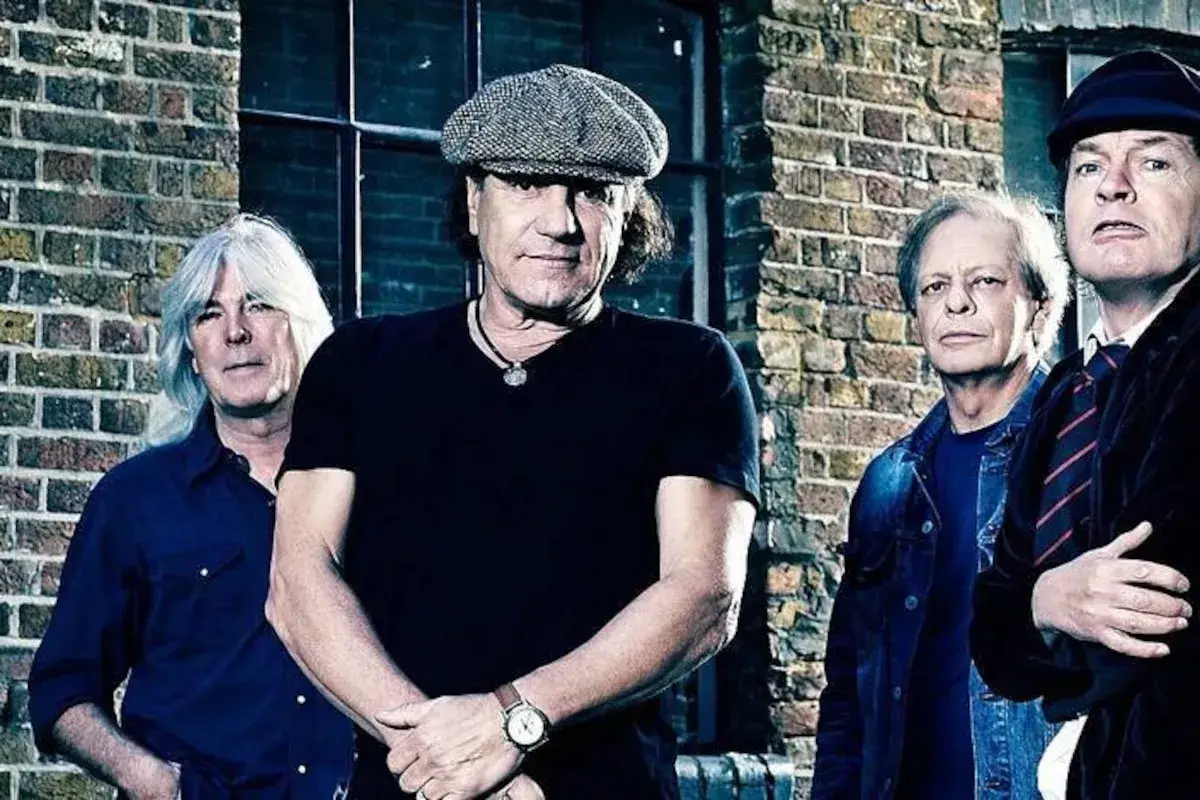 Les membres d'AC/DC posent devant un mur de briques, rappelant l'énergie brute de leurs albums.
