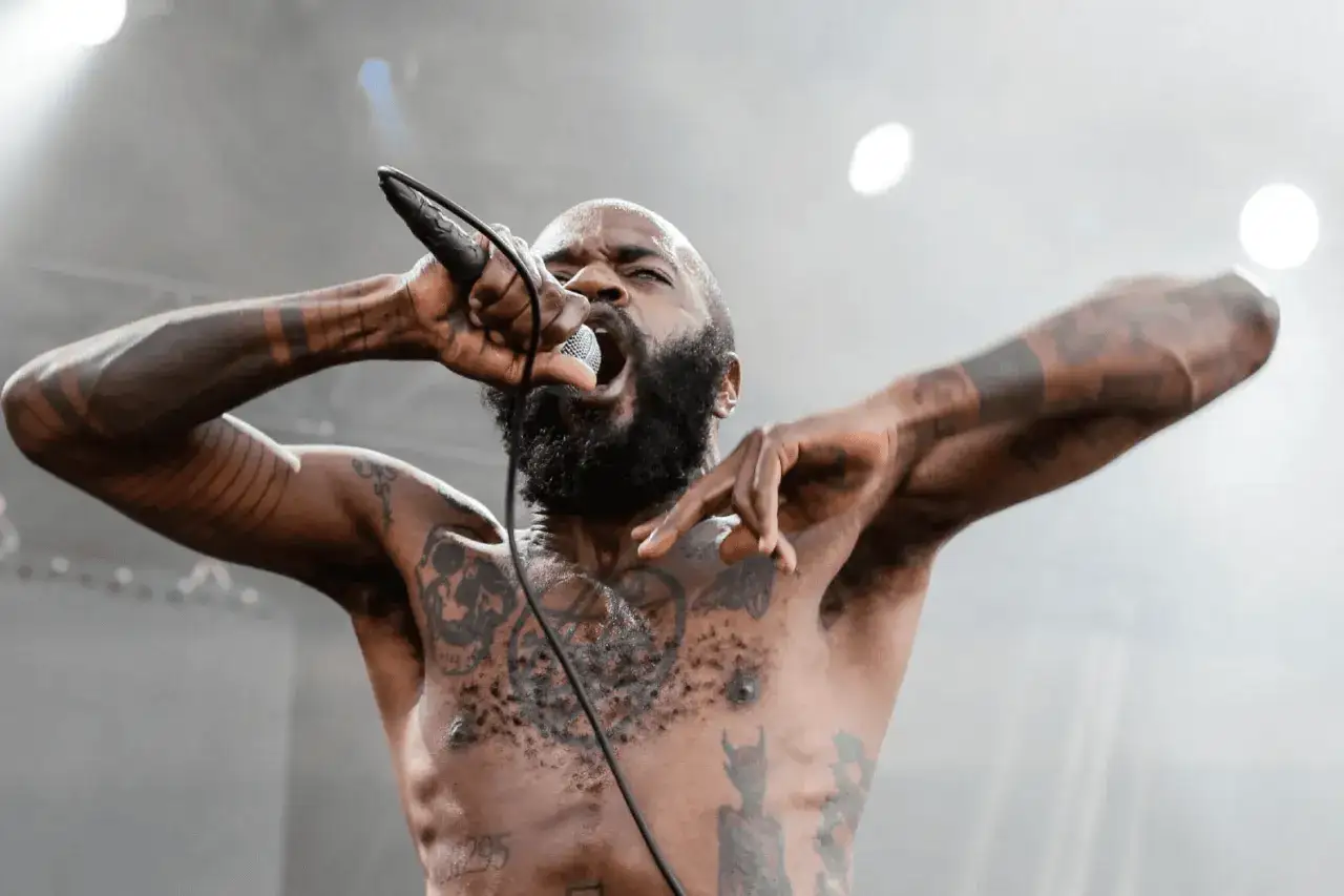 Un rappeur tatou&eacute; hurle dans un micro, bras lev&eacute;s. Une image puissante pour le marketing musical.