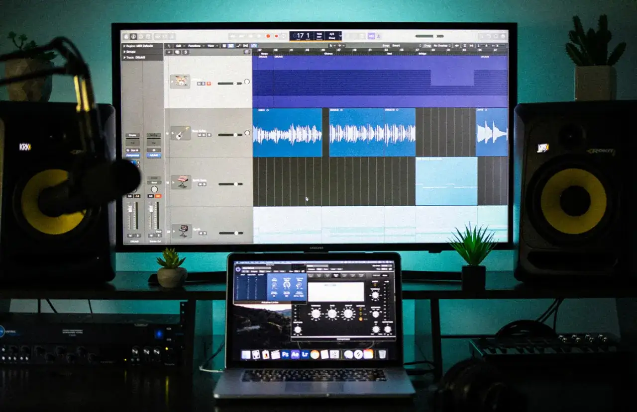 Studio d'enregistrement avec écran affichant un DAW, des enceintes et un ordinateur portable. Idéal pour créer de la musique avec des free daw windows.