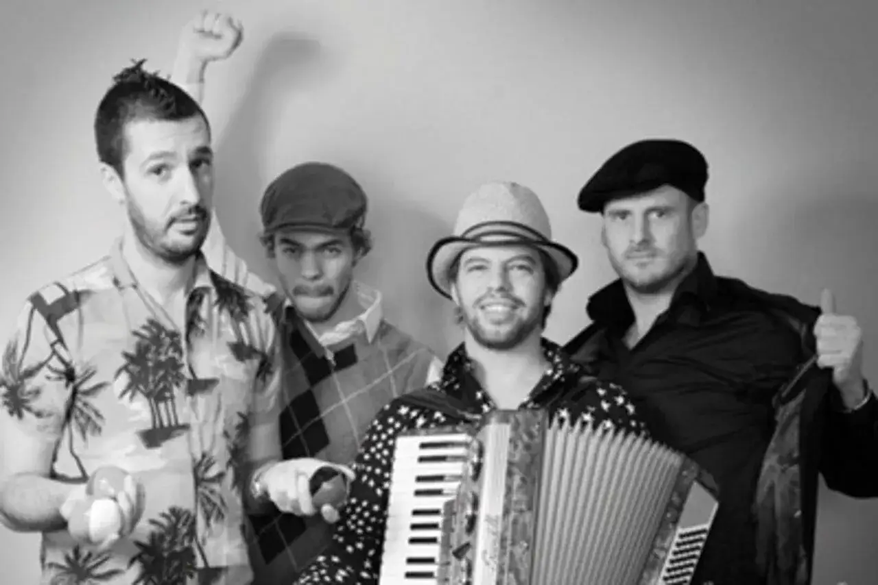 Le groupe java, avec son accord&eacute;oniste au centre, pose joyeusement. L'un des musiciens l&egrave;ve le poing, un autre fait un clin d'&oelig;il.