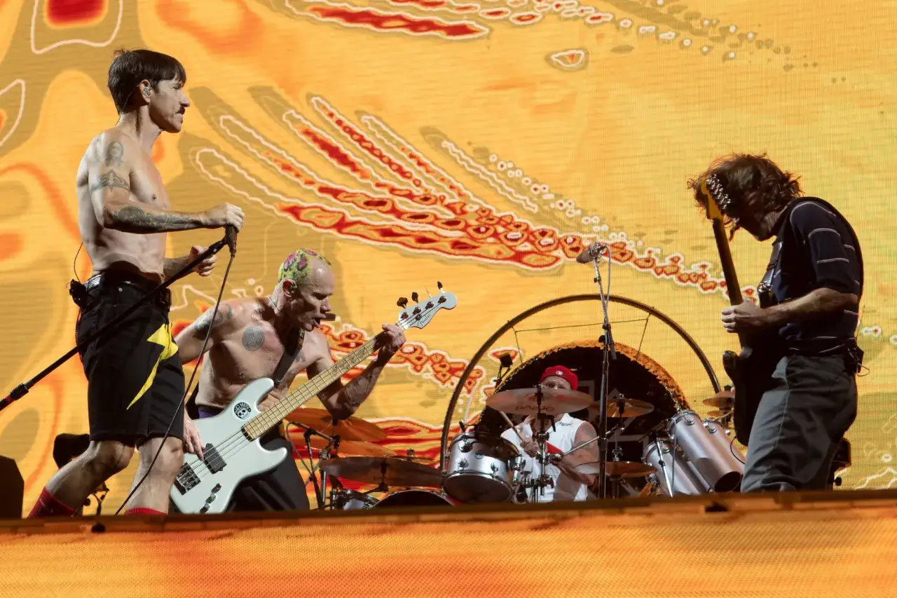 Le groupe Red Hot Chili Peppers en pleine performance, l'énergie est palpable sur scène.