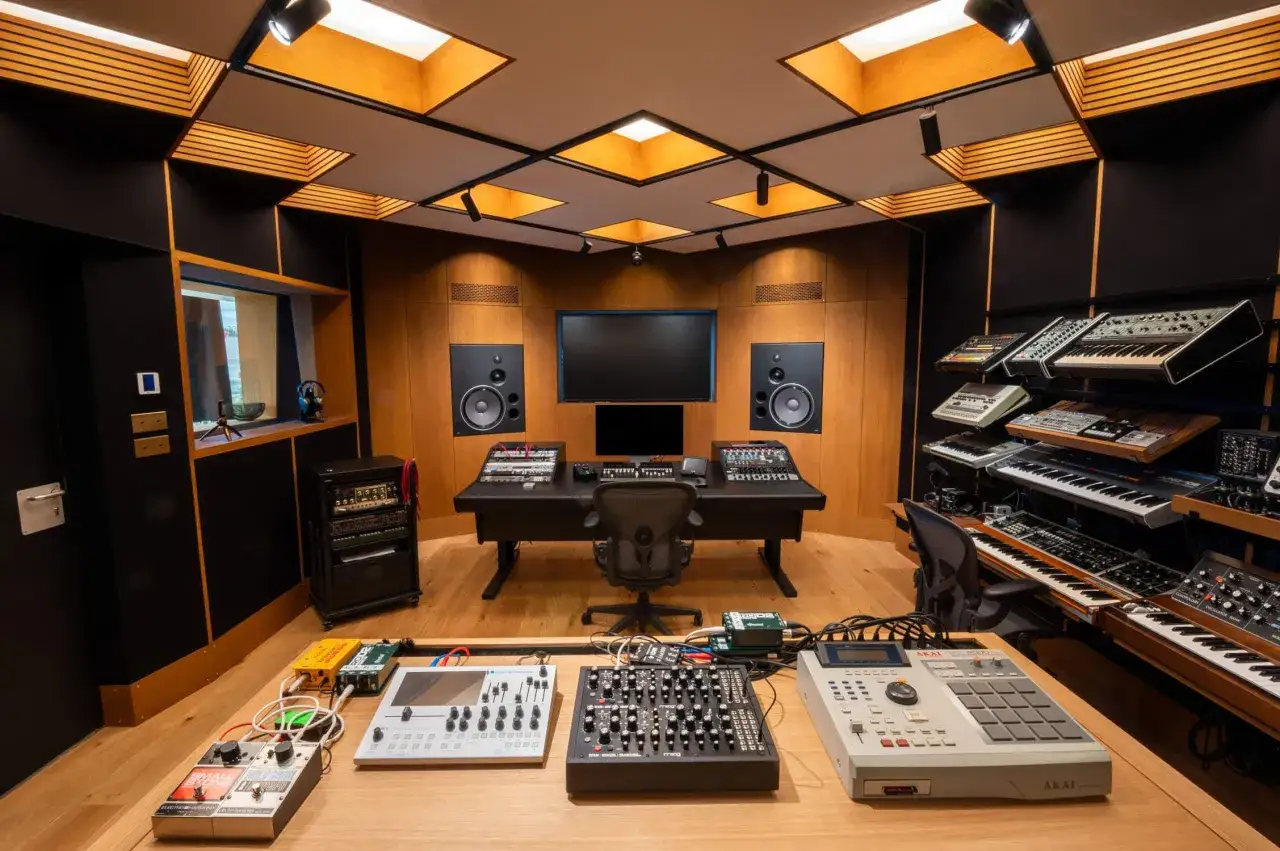 Studio d'enregistrement professionnel avec claviers, tables de mixage et mat&eacute;riel pour l'enregistrement sonore et l'&eacute;dition musicale.