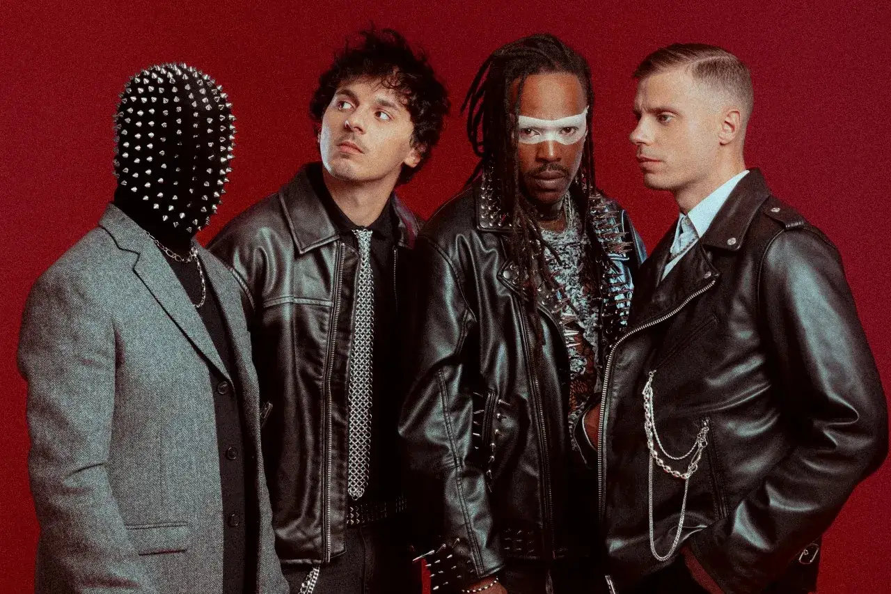 Les membres de Skip the Use posent, l'un masqué de clous, les autres en blousons de cuir et chaînes, sur fond rouge.