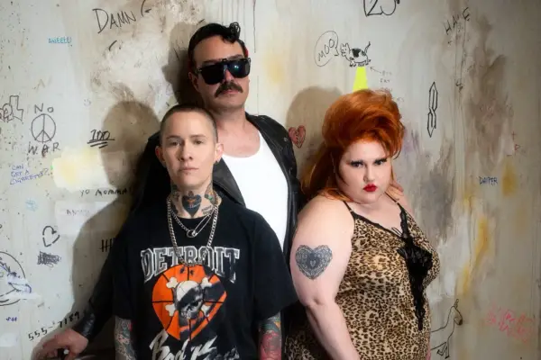 Un groupe d'amis, un vrai gossip groupe, pose devant un mur tagué. L'un porte un t-shirt "Detroit", l'autre une robe léopard, le troisième des lunettes de soleil.
